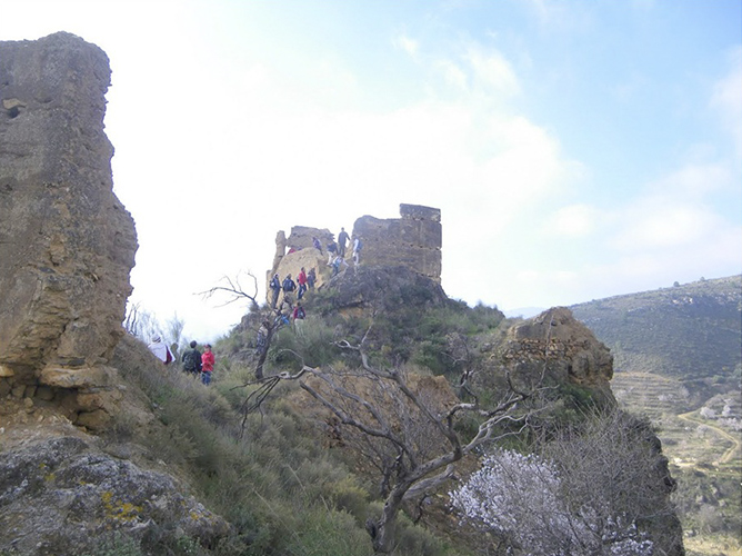 Grupo de personas cruzando un puente colgante de madera en la ruta de Los Cahorros de Monachil Granada